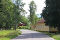 A peaceful village road with wooden houses and trees