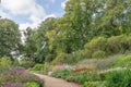 Peaceful walk through herbaceous borders of large English park.