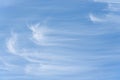 Peaceful wispy white clouds against a clean blue sky as a nature background Royalty Free Stock Photo