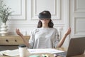 Peaceful woman employee meditating in glasses of virtual reality, sitting in zen pose at workplace Royalty Free Stock Photo