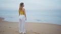 Peaceful woman enjoy ocean waves on evening beach. Girl standing sand seashore Royalty Free Stock Photo