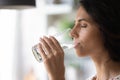 Peaceful woman satisfying thirst, drinking fresh pure clear cold water