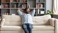 Peaceful young african american man stretching back, relaxing on couch. Royalty Free Stock Photo