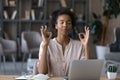 Peaceful young african ethnicity woman reducing stress at workplace. Royalty Free Stock Photo