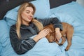 Serene woman dozing off with her dog in bedroom Royalty Free Stock Photo