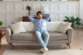 Peaceful young handsome man relaxing on comfortable couch.