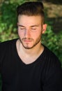 Peaceful young man with eyes closed, relaxing outdoors in nature