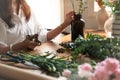 Peaceful young woman arranging flowers on wooden table. Leisure activity and lifestyle concept Royalty Free Stock Photo