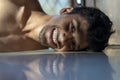 Peacefulness concept. Creative portrait of a young man lying on a reflective floor