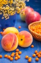 Peach, apple and sea buckthorn on a wooden background. Close-up.