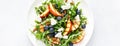 Peach, blueberry and arugula fresh fruit salad with cheese and almond nuts. Top view. Banner