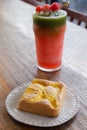 Peach chiffon cake on the white plate and cold blended watermelon with ice and green tea smoothie drink on the wooden table at the Royalty Free Stock Photo