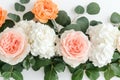 Peach-colored roses and white roses are arranged with eucalyptus on a purely white and clean surface Royalty Free Stock Photo