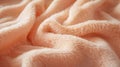 Peach-colored towel with intricate textures and folds, highlighting its fluffiness and warmth.