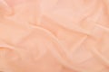 Peach coral soft chiffon fabric texture. Delicate folded cloth silk, organza, crepe chiffon background. Fashion elegant wedding Royalty Free Stock Photo