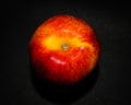 Peach on a dark background. Photo of fruit on a black background. Photo of a red single peach on a dark paper background Royalty Free Stock Photo