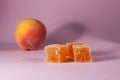 Peach marmalade on pink background with copy space. Close-up, selective focus. Delicious, juicy homemade sweets