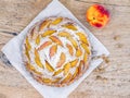 Peach pie with sugar powder over a piece of paper