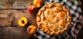 A peach pie on a wooden table with sliced peaches Royalty Free Stock Photo