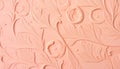 Close up of a peach colored textured surface with embossed floral and leaf patterns Royalty Free Stock Photo