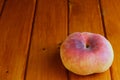 A peach on a wooden surface