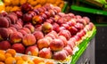 Peaches and apples and fruit for sale on an outdoor market