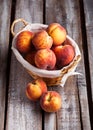 Peaches in basket on old wooden table Royalty Free Stock Photo