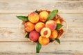 Peaches in a basket on a wooden background with a slice of sliced juicy peach with a stone Royalty Free Stock Photo