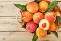 Peaches in a basket on a wooden background with a slice of sliced juicy peach with a stone. Royalty Free Stock Photo