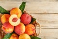 Peaches in a basket on a wooden background with a slice of sliced juicy peach with a stone Royalty Free Stock Photo