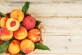 Peaches in a basket on a wooden background with a slice of sliced juicy peach with a stone Royalty Free Stock Photo