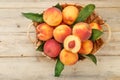 Peaches in a basket on a wooden background with a slice of sliced juicy peach with a stone Royalty Free Stock Photo