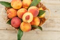 Peaches in a basket on a wooden background with a slice of sliced juicy peach with a stone. Royalty Free Stock Photo