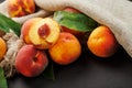 Peaches on a black background with burlap fabric and green leaves. Sweet and juicy peach slices with a stone Royalty Free Stock Photo