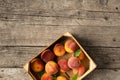 Peaches in a box on a wooden background top view Royalty Free Stock Photo