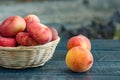 Ripe peaches in a wicker basket on a dark wooden background Royalty Free Stock Photo