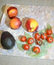 Peaches nectarine, avocado and cherry tomatoes on laure Royalty Free Stock Photo