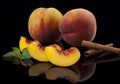 Peaches, whole and cut on a black mirror background Royalty Free Stock Photo