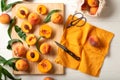 Peaches whole fruits with leaves, peaches in halves, peach slices on a white kitchen table. The process of making peach jam, Royalty Free Stock Photo