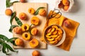 Peaches whole fruits with leaves, peaches in halves, peach slices on a white kitchen table. The process of making peach jam, Royalty Free Stock Photo