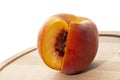 Peaches on a wooden board. Peach in half with a stone. Ripe juicy fruits Royalty Free Stock Photo