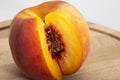 Peaches on a wooden board. Peach in half with a stone. Ripe juicy fruits Royalty Free Stock Photo