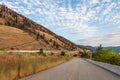PEACHLAND, CANADA - AUGUST 01, 2020: asphalt road between mountain and okanagan lake beautiful landscape with cloudy sky