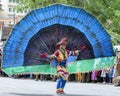 A Peacock Dancer performs along a street in Kandy