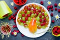 Peacock fruit berry plate, colorful peacock fruit salad from pear, grapes and raspberries Royalty Free Stock Photo