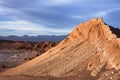 A peak in moon valley in the atacama desert (driest desert on earth) is bathed in the light of the setting sun in front of a storm Royalty Free Stock Photo