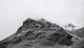 A peak of a mountain in the Alps with fog and clouds above the valley Peio, Trentino, Italy