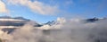 Peak of mountain range  emerging of white  clouds in alps Royalty Free Stock Photo