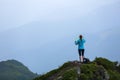 On the peak of the mountain the touris girl with the map and compass is searching for the way to dream. The horizon in the fog. Royalty Free Stock Photo