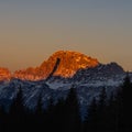 The peak of the mountains of the dolomites during sunset. High mountain landscape of the Dolomites in winter. Fantastic orange